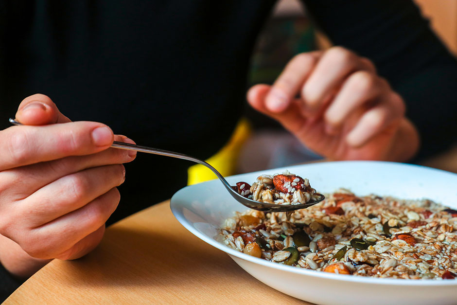 Junger Mann ist einen Teller Haferflocken | Credit: iStock.com/R.Igor