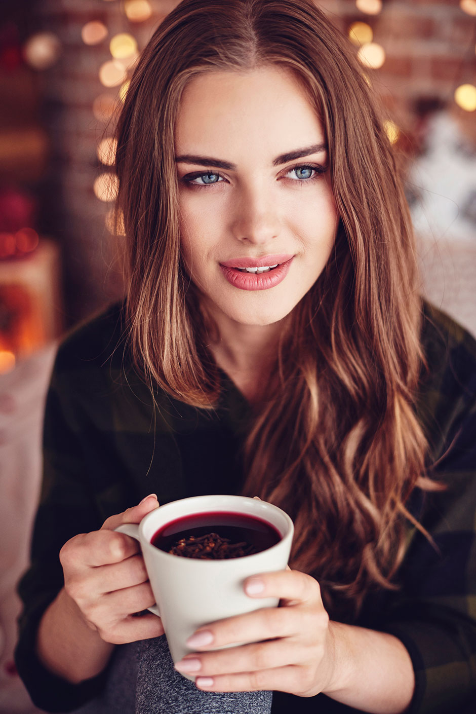 Junge Frau genießt eine Tasse Glühwein | Credit: iStock.com/gpointstudio
