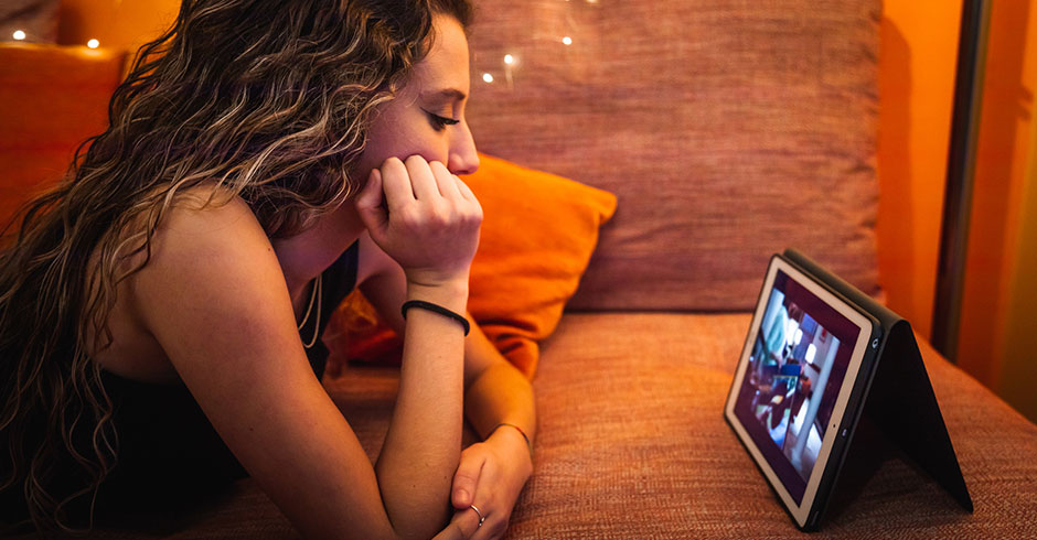 Junge Frau sieht ihre Lieblingsserie auf dem Tablet an | Credit: iStock.com/Jorge Garcia Argazkiak