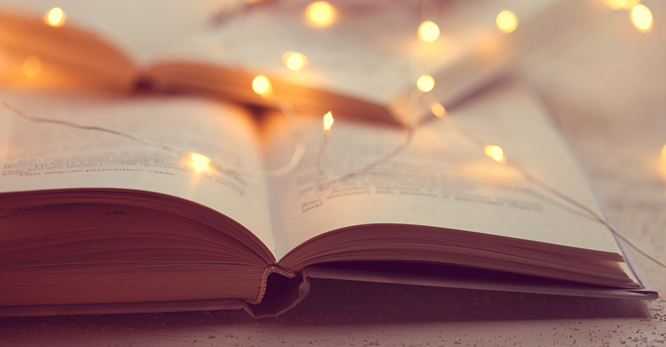 Aufgeschlagenes Buch mit Weihnachtsbeleuchtung | Credit: iStock.com/yul38885