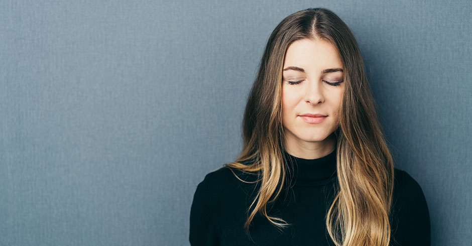 Frau träumt mit geschlossenen Augen vor sich hin | Credit: iStock.com/stockfour