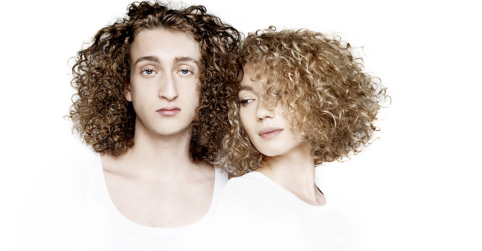 Junger Mann und junge Frau in weißer Kleidung mit Locken