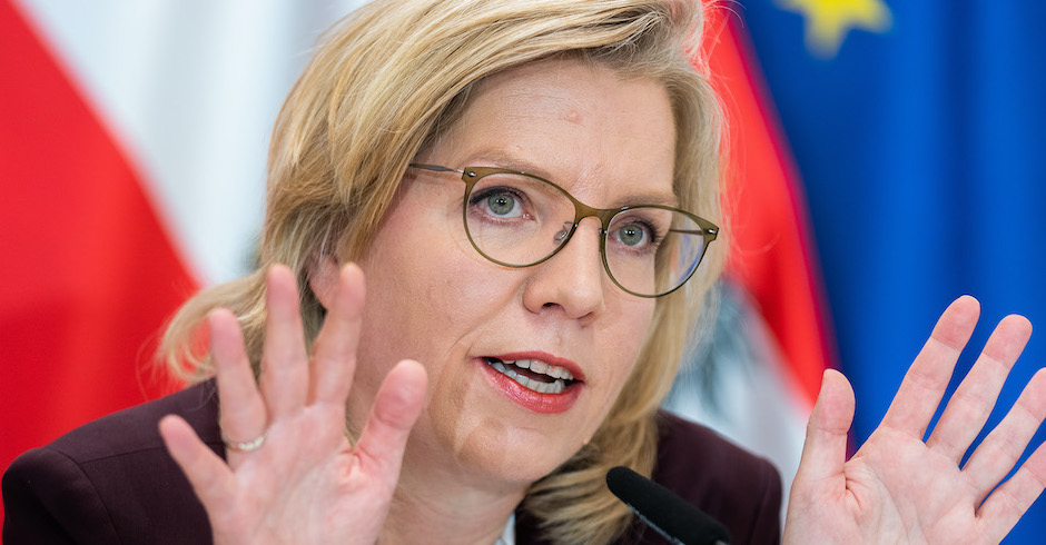 Porträt der Ministerin mit neben dem Gesicht erhobenen Händen