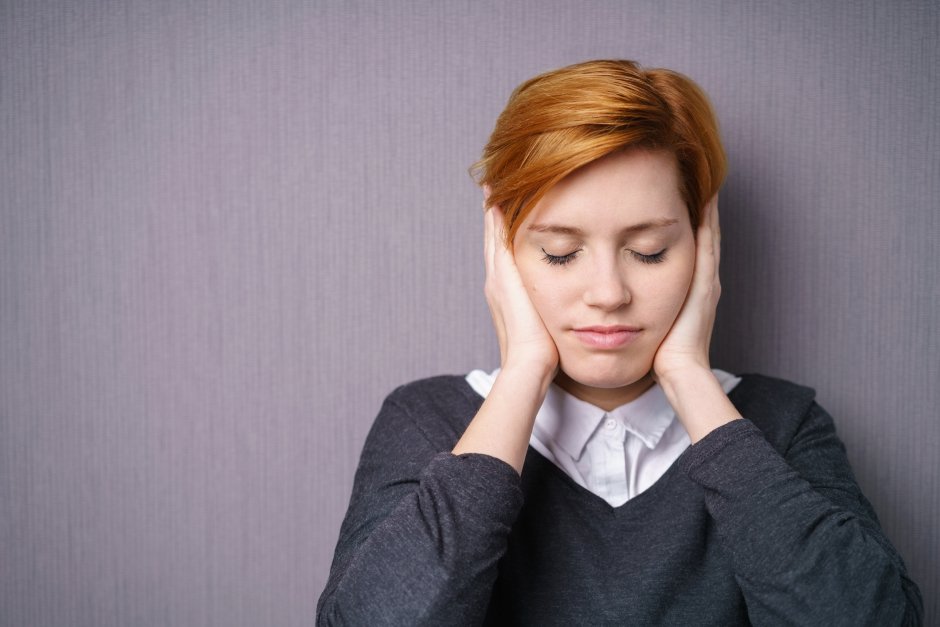 Junge Frau hält sich die Ohren zu | Credit: iStock.com/stockfour