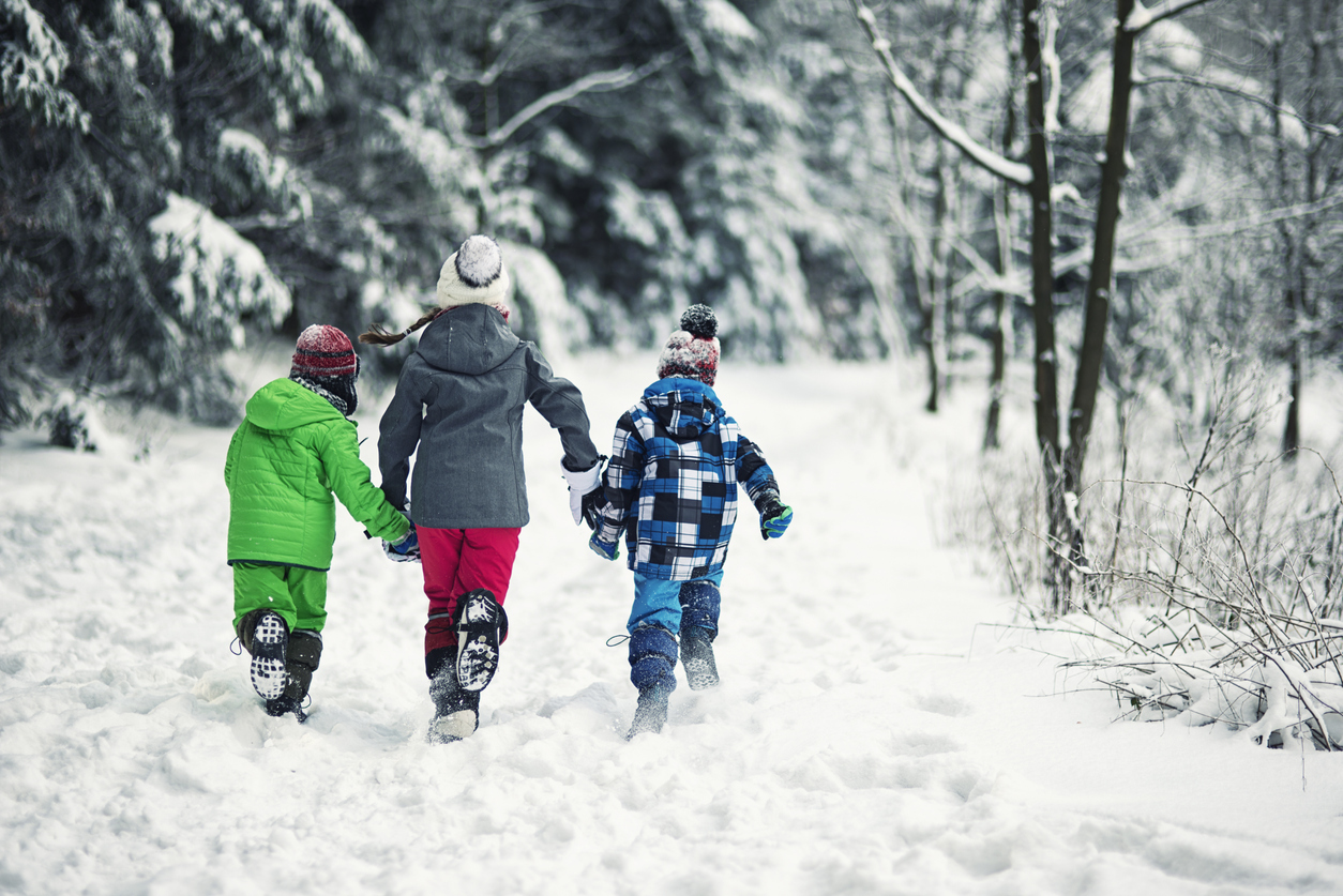 Drei Kinder im winterlichen Wald