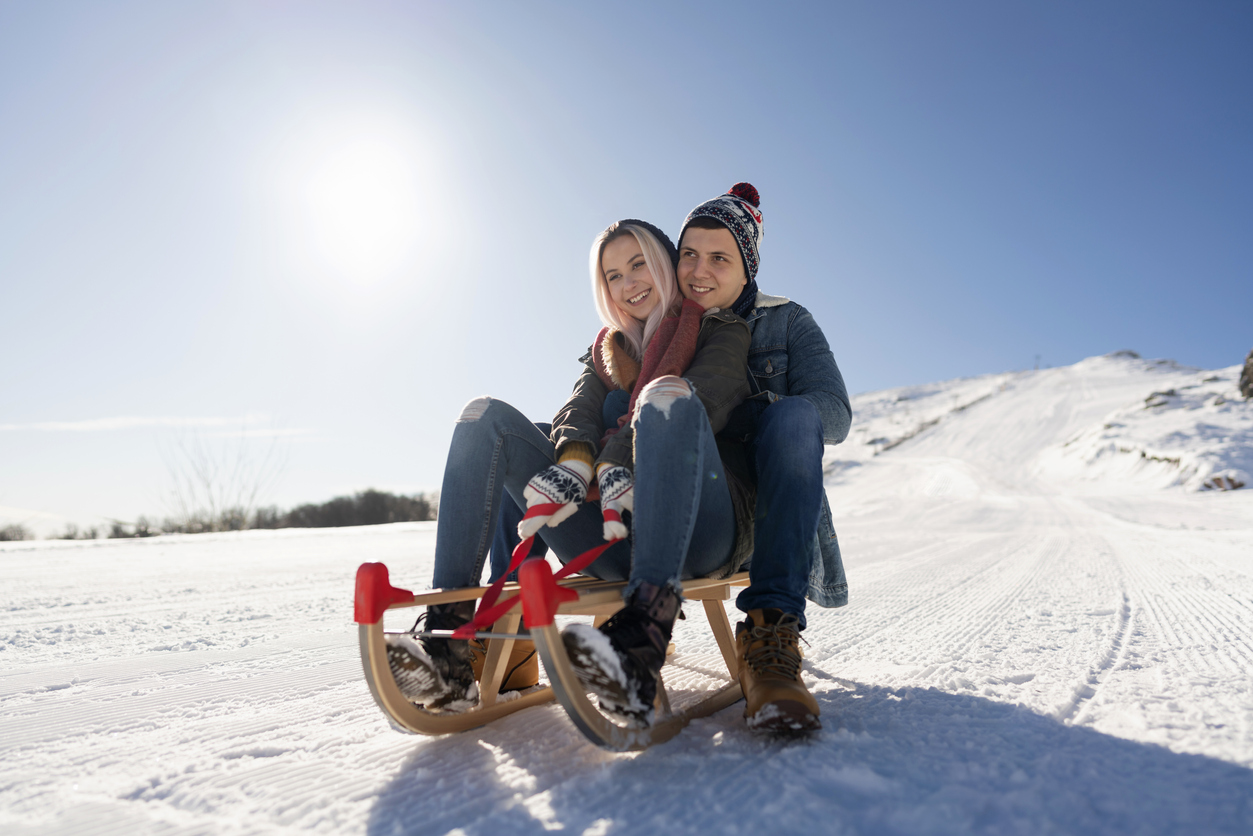 Zwei Erwachsene auf einem Rodel