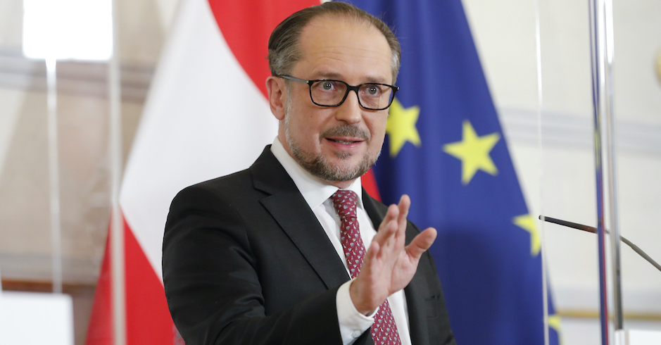 Alexander Schallenberg vor der österreichischen und europäischen Flagge.