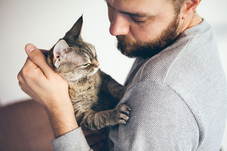 Mann kuschelt mit seiner Katze | Credit: iStock.com/insonnia