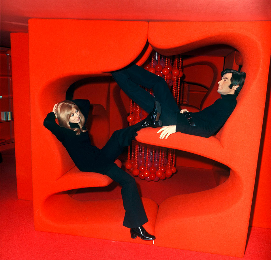 Junges Paar sitzt auf Sofas in futuristischem Design bei der Möbelmesse 1970 in Köln | Credit: Fritz Reiss / dpa / picturedesk.com