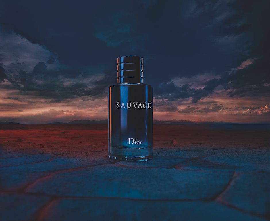 Parfümflakon mit der Aufschrift Sauvage Dior vor düsterem Himmel