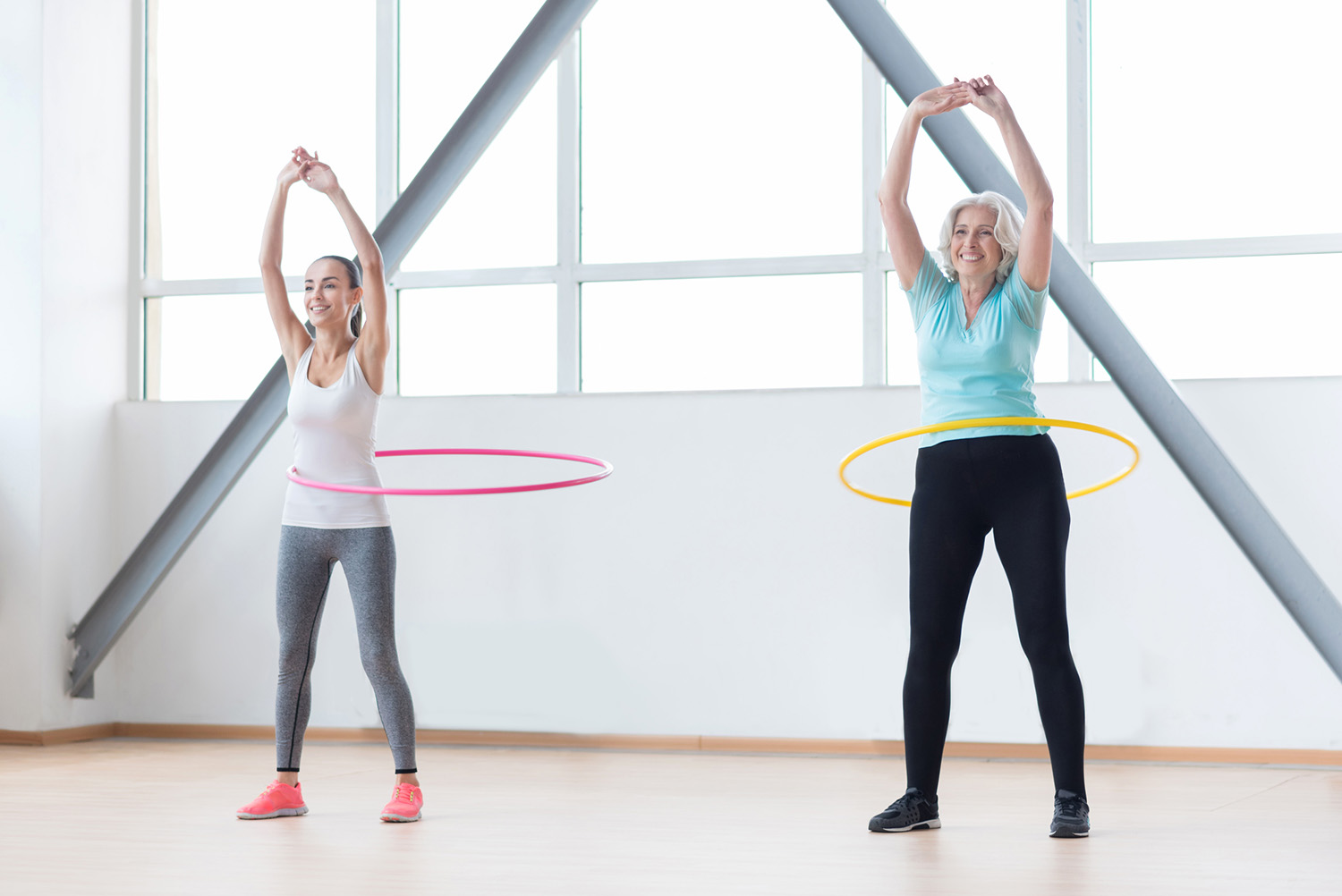 Zwei Frauen trainieren mit Hula Hoop-Reifen | Credit: iStock.com/yacobchuk