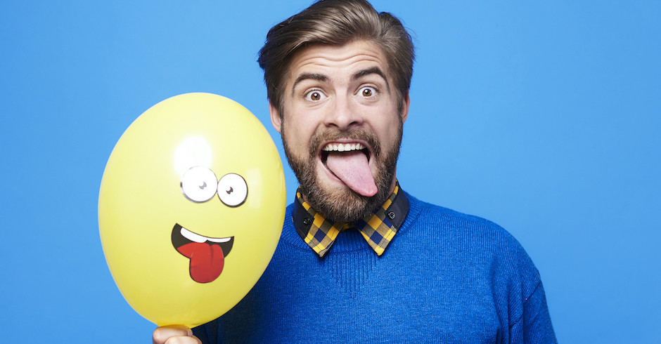 Mann im blauen Pullover zeigt Zunge | Credit: iStock.com/gpointstudio