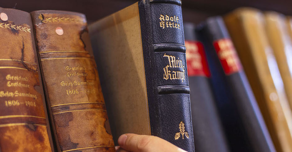 Frauenhand entnimmt Buch aus Bücherregal