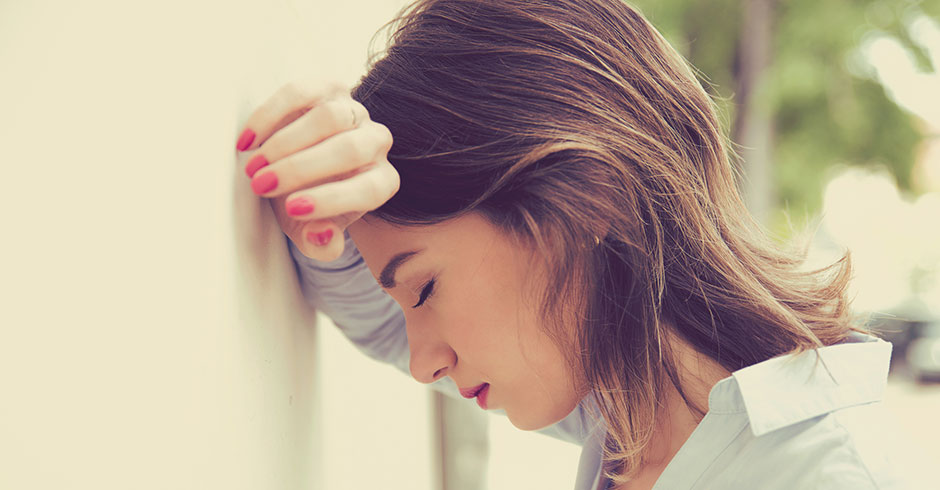 Erschöpfte junge Frau stützt ihren Kopf gegen die Wand | Credit: iStock.com/SIphotography