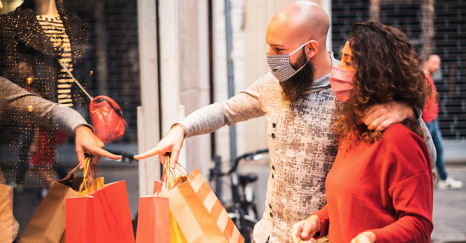 Mann und Frau stehen mit Maske vor einem Schaufenster