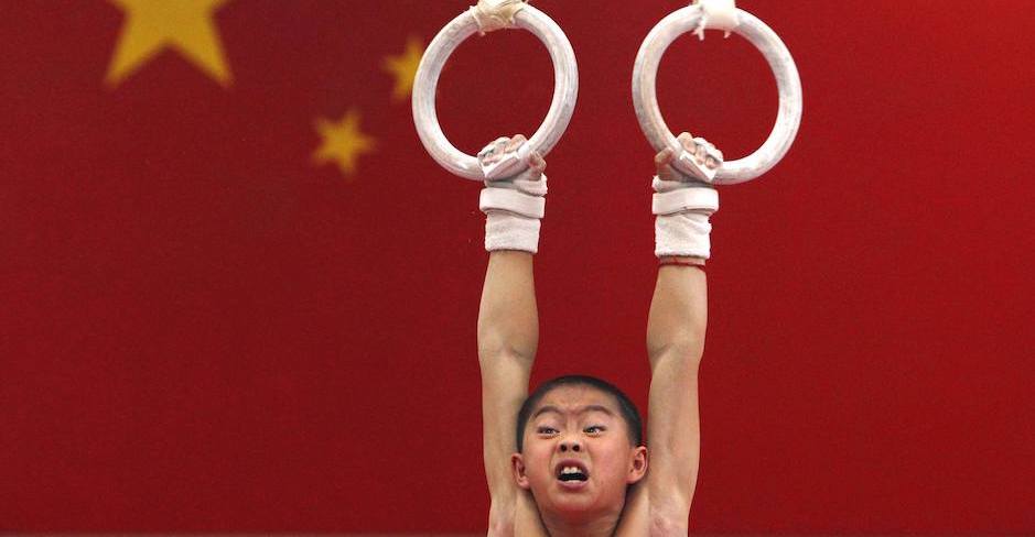 Ein Junge hängt mit verzerrtem Gesicht an Ringen