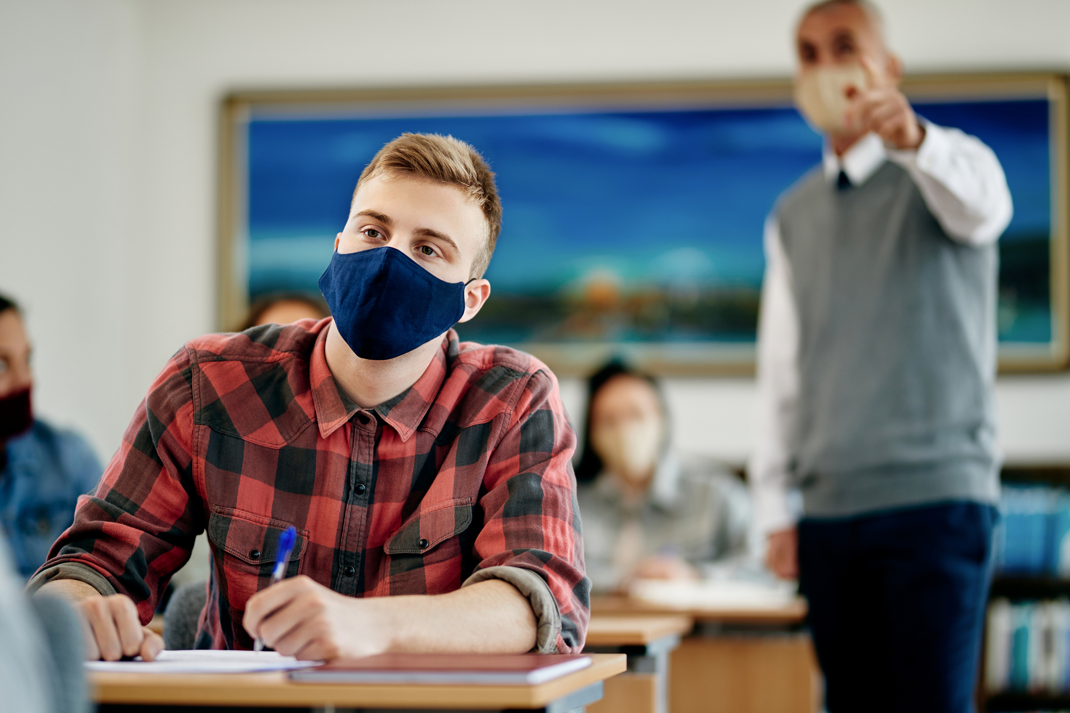 Schüler sitzt mit FFP2-Maske in der Klasse | Credit: iStock.com/Drazen Zigic
