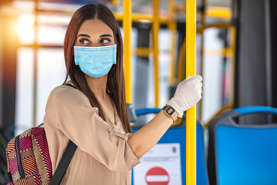 Frau mit Maske, unterwegs in einem Autobus | Credit: iStock.com/dragana991