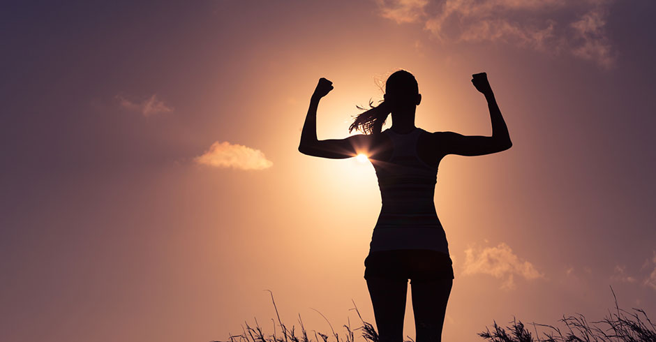 Frau streckt voller Energie ihre geballten Fäuste in die Luft | Credit: iStock.com/kieferpix