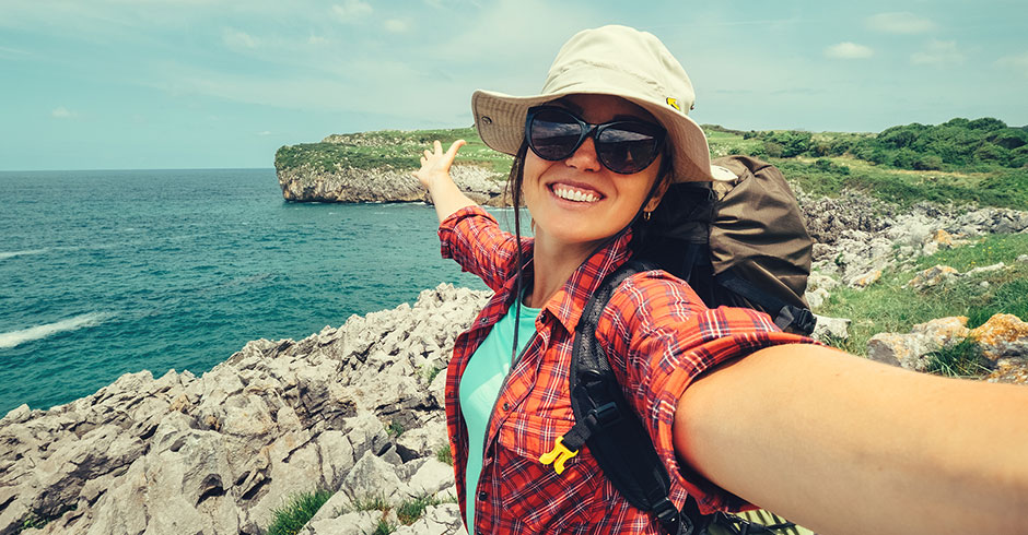 Junge fröhliche Rucksacktouristin | Credit: iStock.com/Solovyova