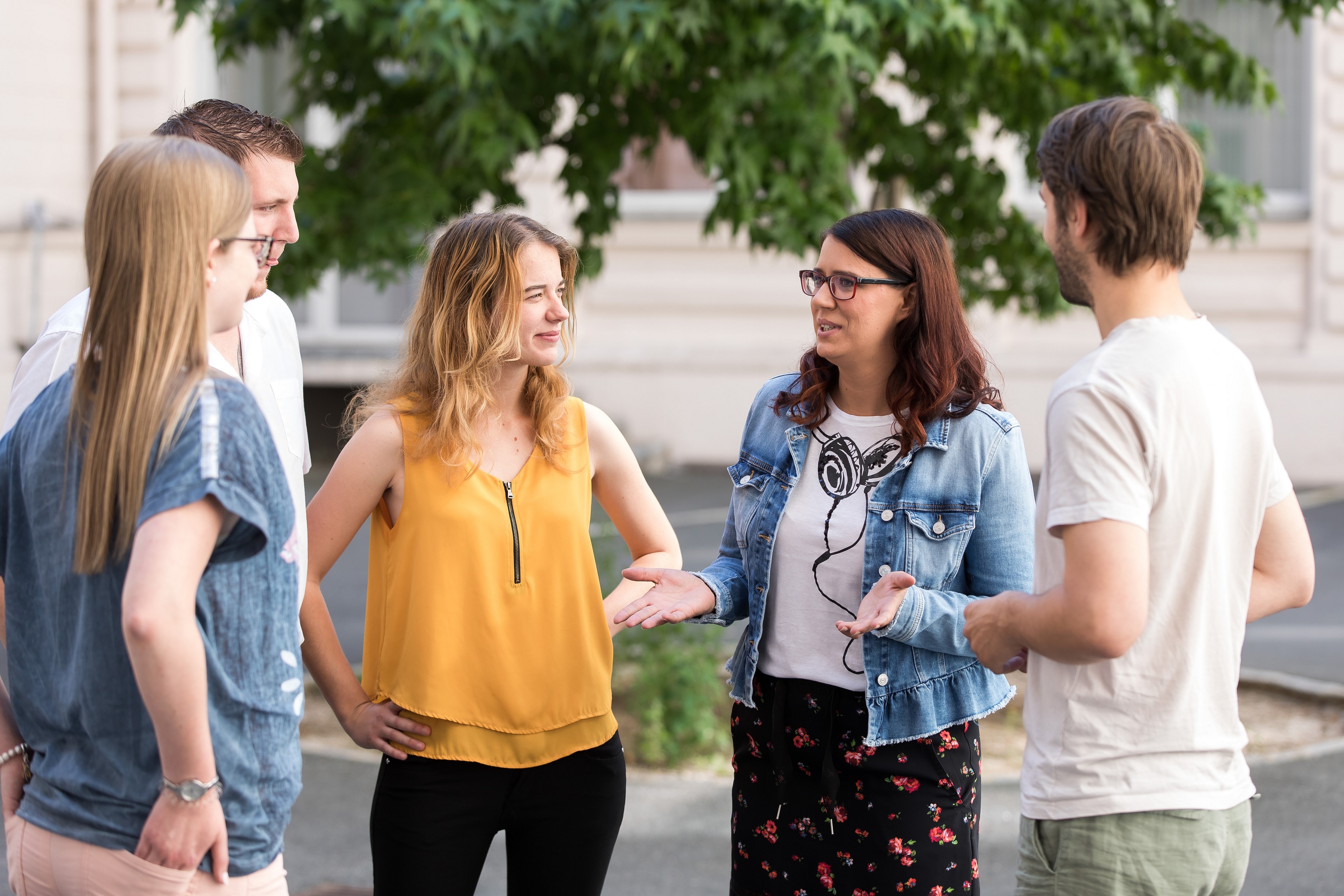 LR Sara Schaar steht mit vier Jugendlichen in einer Gesprächsrunde zusammen