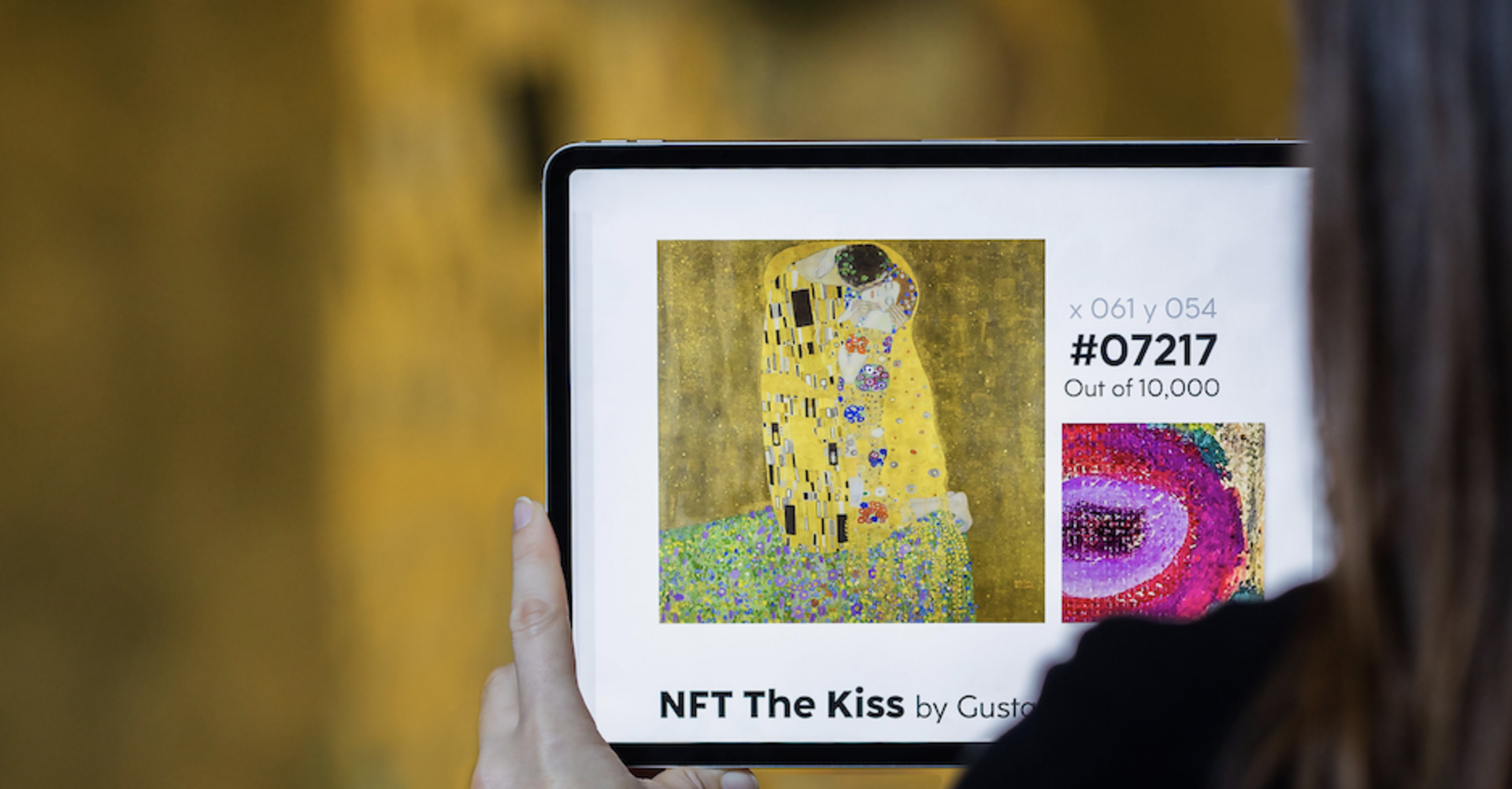 Frau von hinten fotografiert, richtet Tablet auf Gemälde