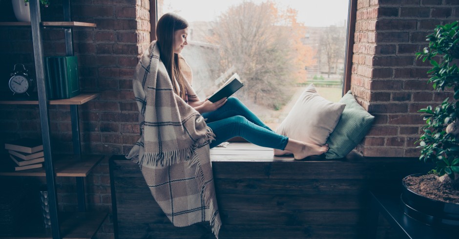 Frau sitzt auf Bank und liest | Credit: iStock.com/Deagreez