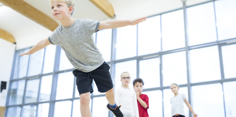 Ein Junge balanciert mit ausgestreckten Armen