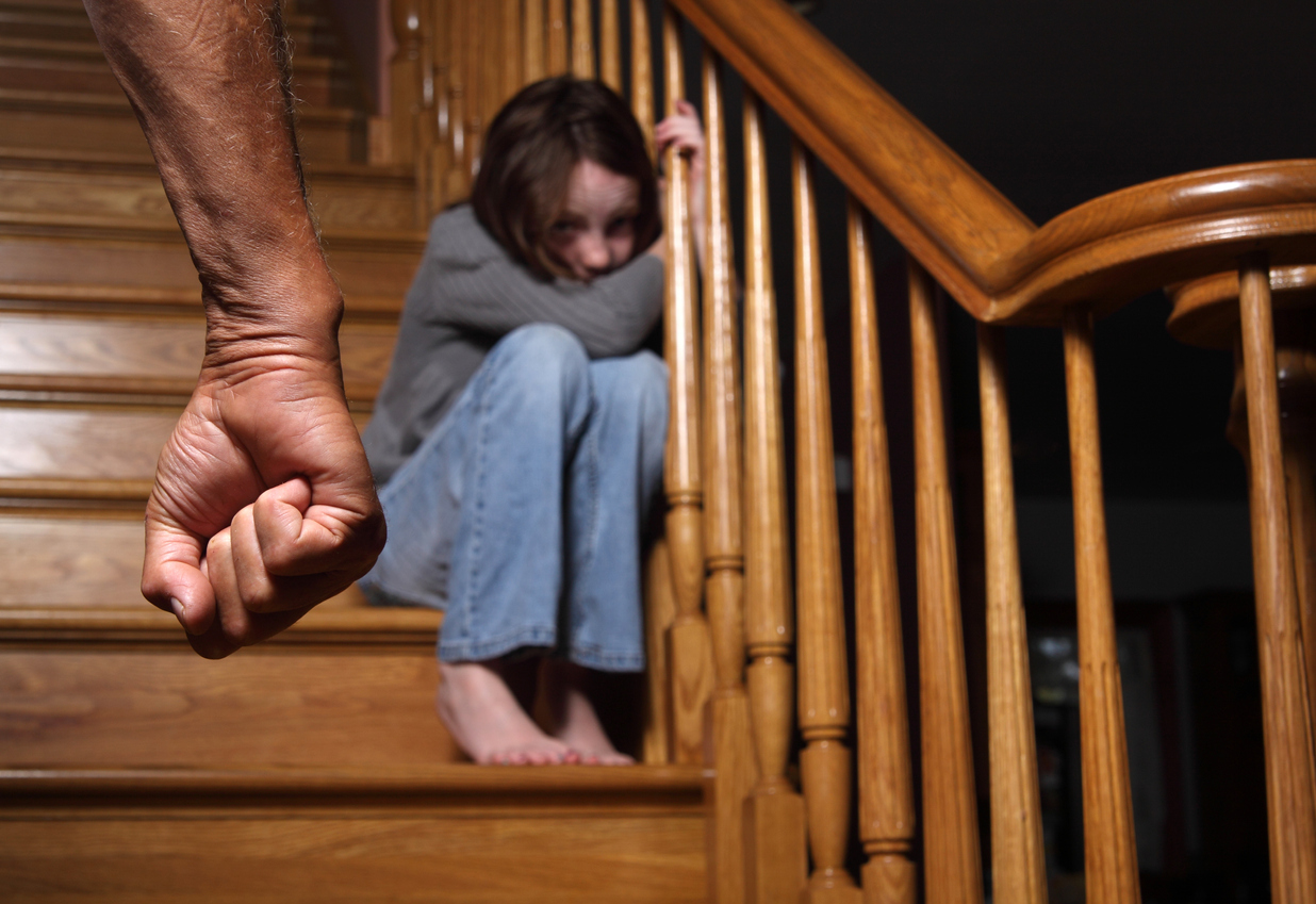 Ein Mädchen sitzt verängstigt auf der Treppe