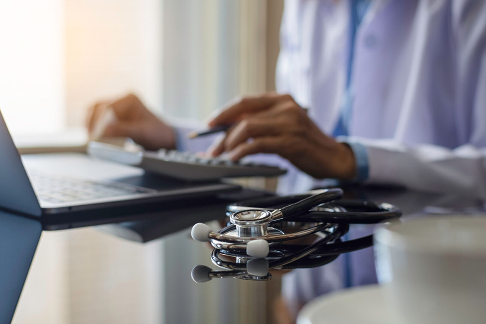 Ärztin trägt am Computer Patientendaten ein | Credit: iStock.com/Everyday better to do everything you love