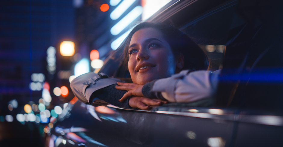 Frau blickt während der Fahrt entspannt aus dem geöffneten Seitenfenster | Credit: iStock.com/gorodenkoff
