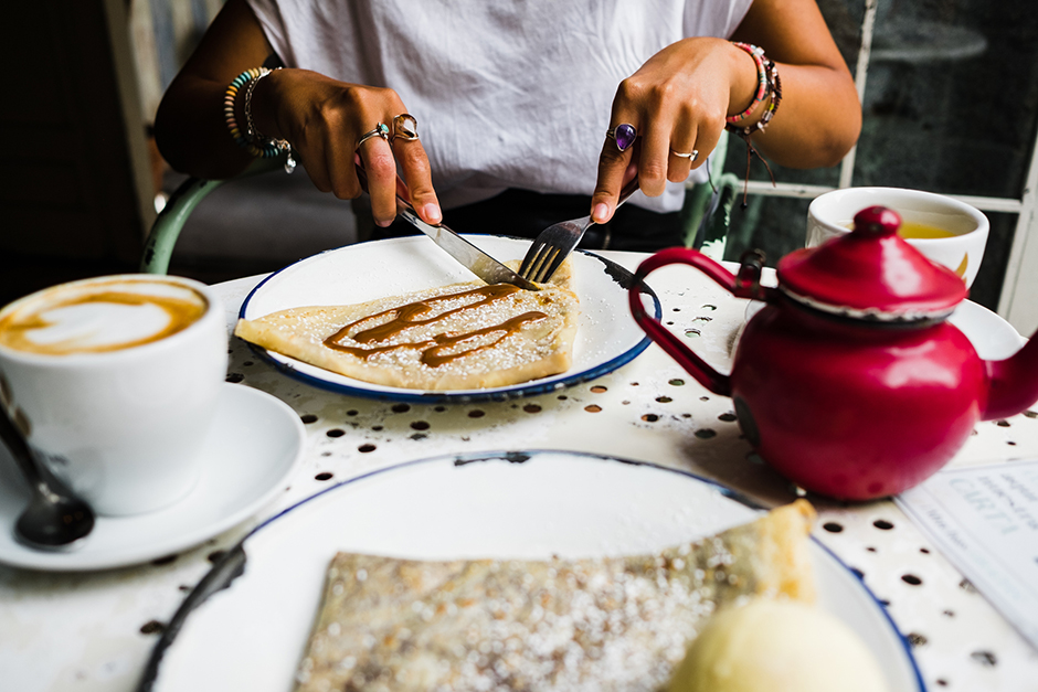 Junge Frau beim Verspeisen einer Crêpe | Credit: iStock.com/Alba Caro