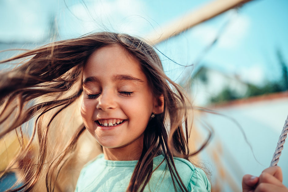 Fröhliches Mädchen auf der Schaukel | Credit: iStock.com/Kerkez