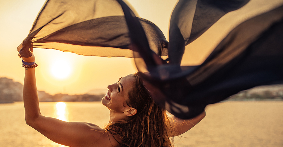Junge Frau genießt den Sonnenuntergang | Credit: iStock.com/bernardbodo
