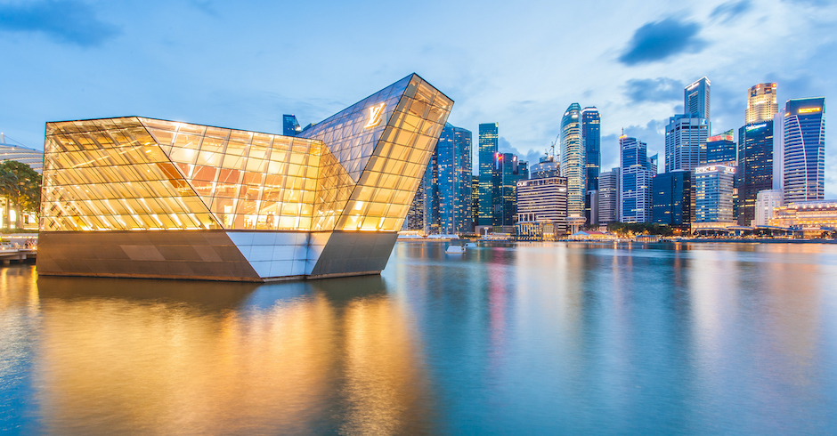 Beleuchtetes Gebäude mit Logo und Spiegelung im Wasser
