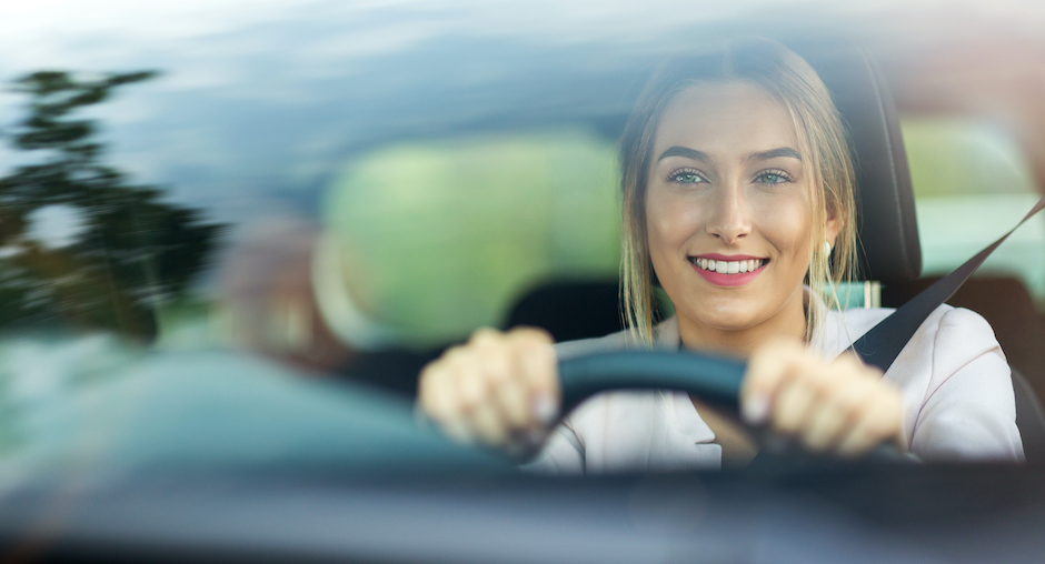 Frau lächelt beim Autofahren | Credit: iStock.com/PIKSEL