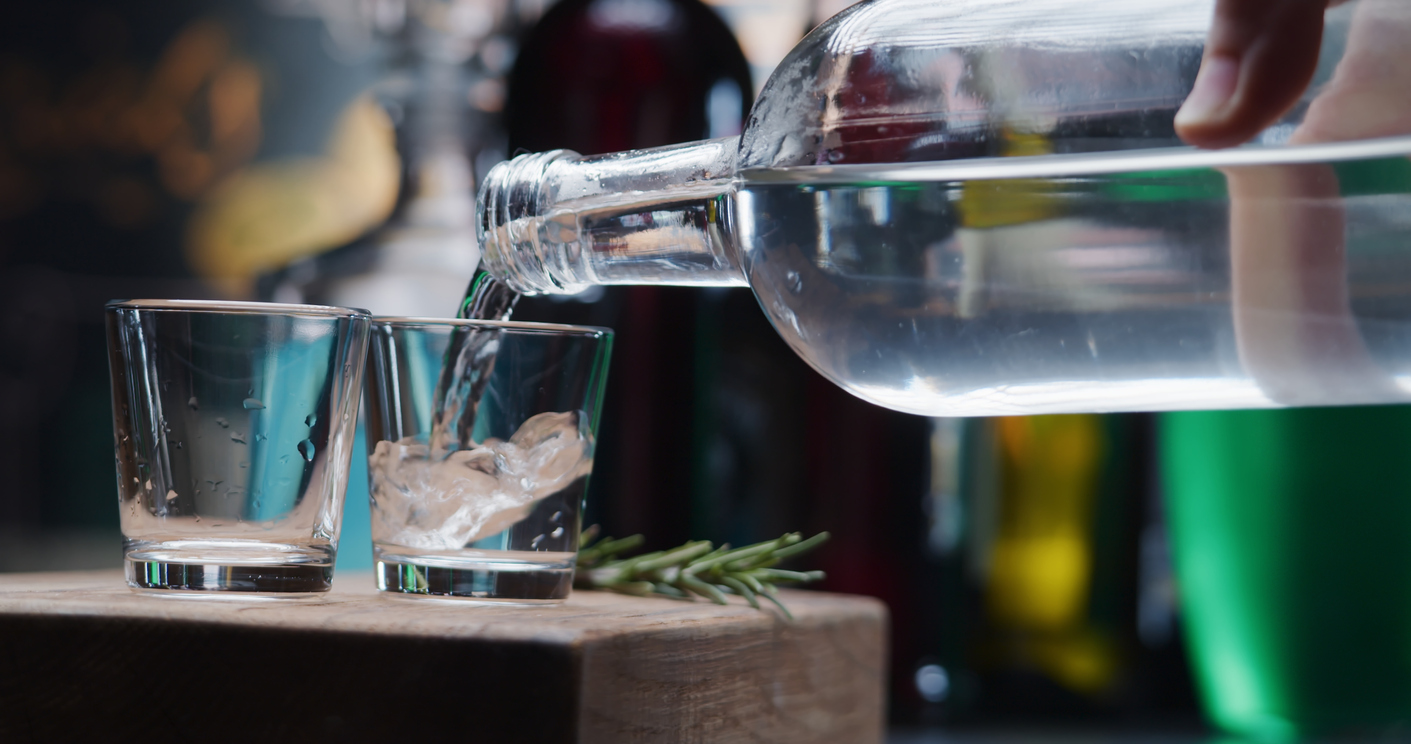 Mann schenkt Vodka in zwei Gläser ein