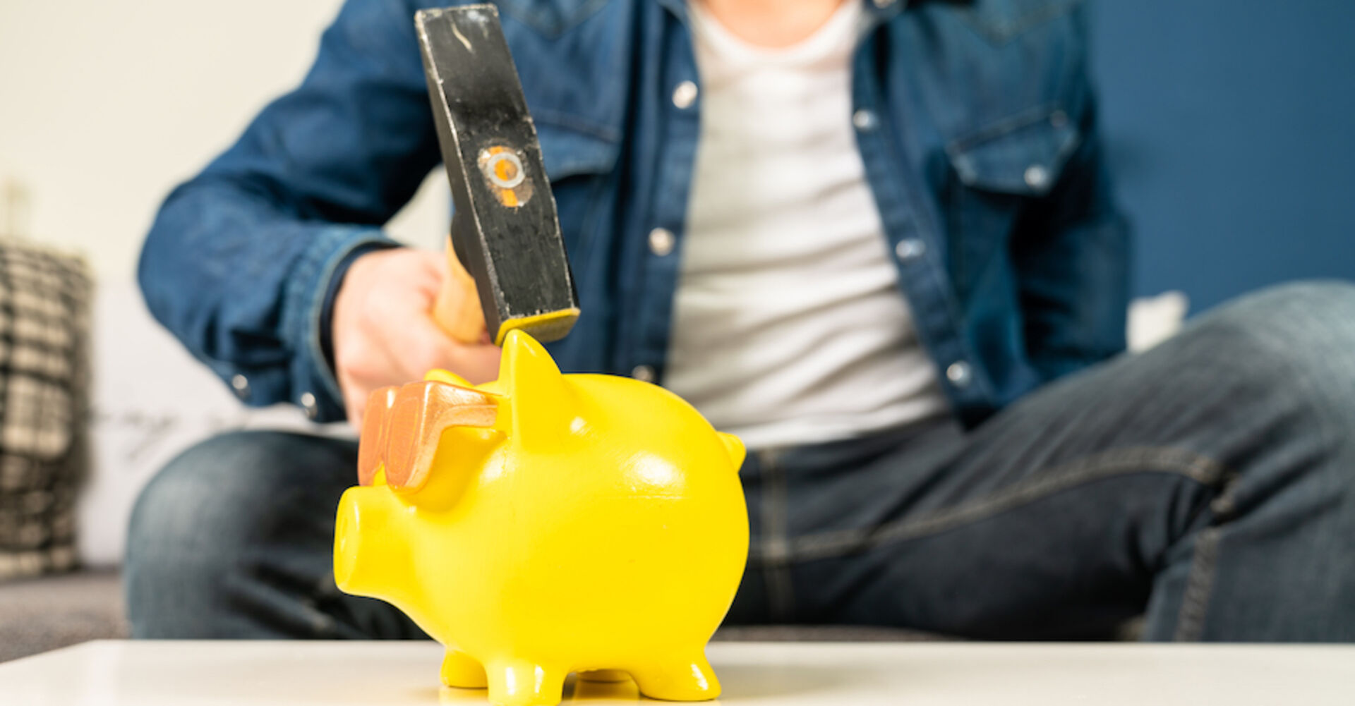 Mann zerschlägt gelbes Sparschwein | Credit: iStock.com/Jens Rother