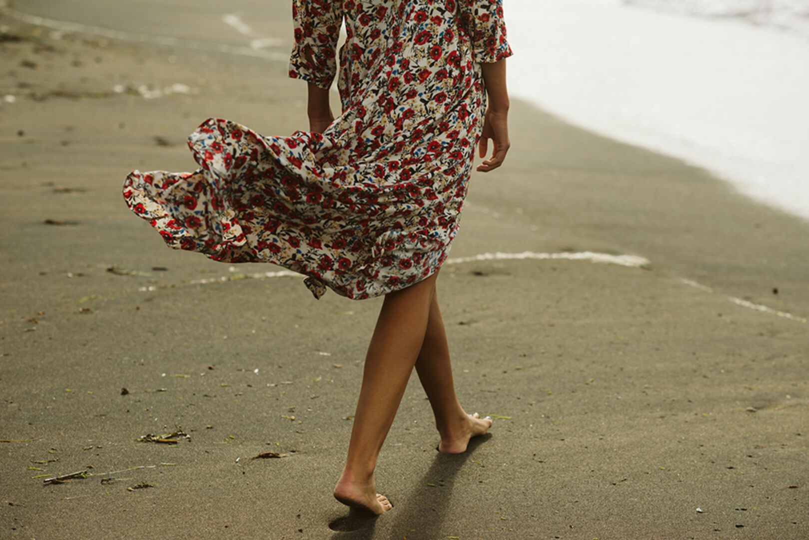 Junge Frau bei einem Strandspaziergang | Credit: iStock.com/Iker Martiarena