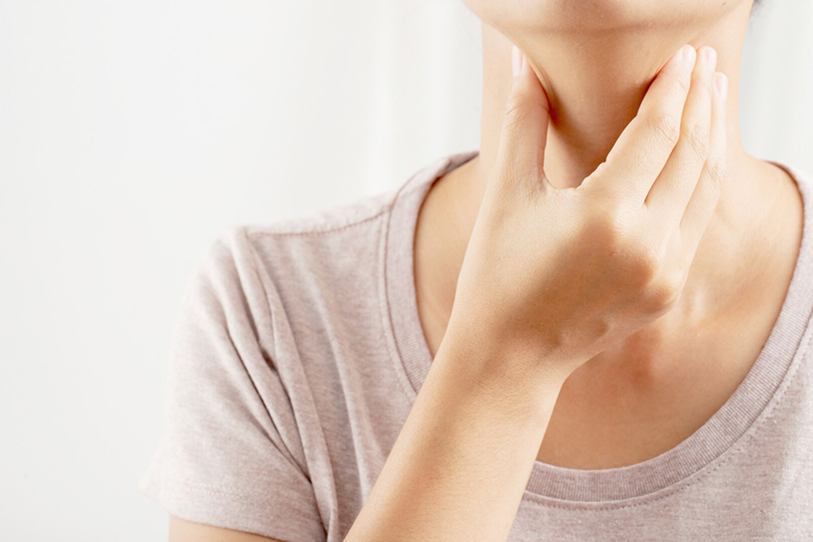 Frau tastet ihren Hals ab | Credit: iStock.com/Kamonwan Wankaew