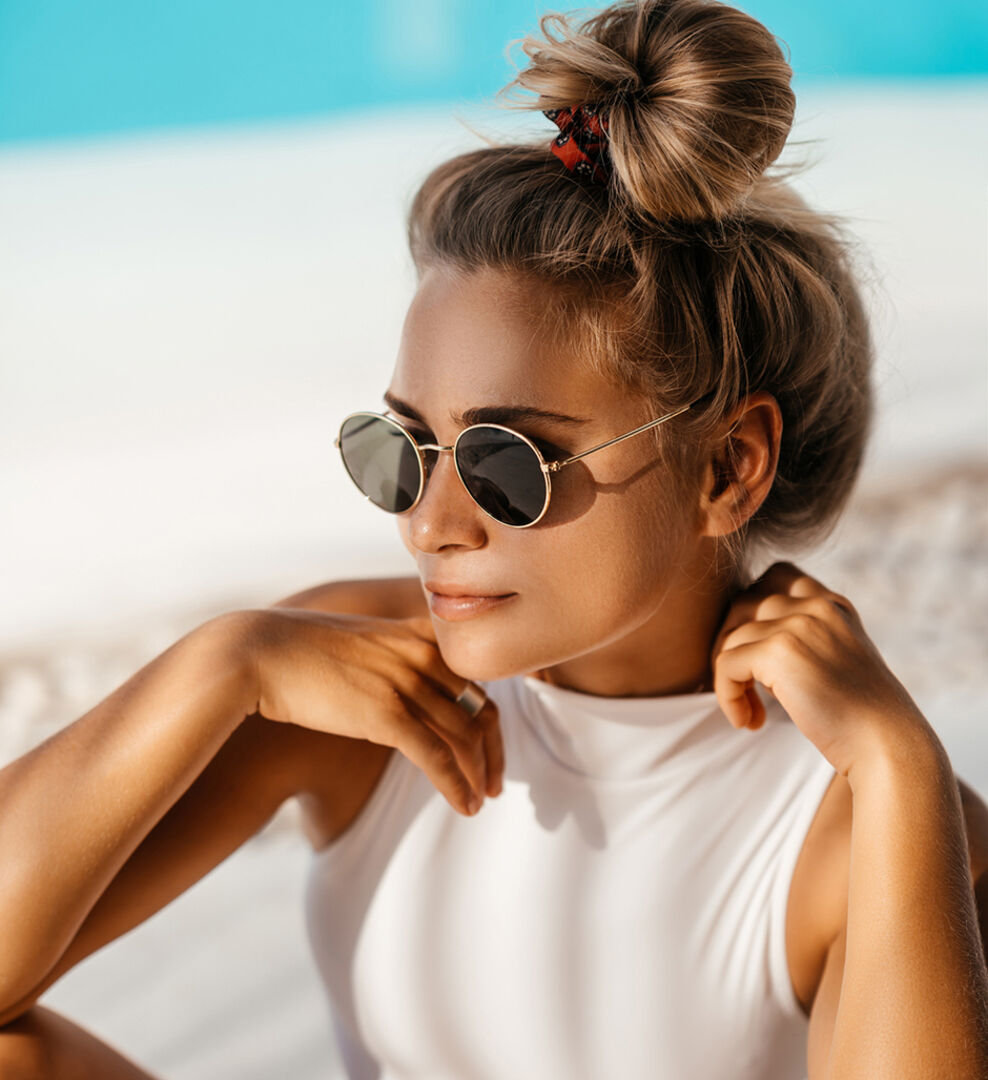 Junge Frau mit locker aufgesteckten Haaren am Strand | Credit: iStock.com/Margaryta Basarab