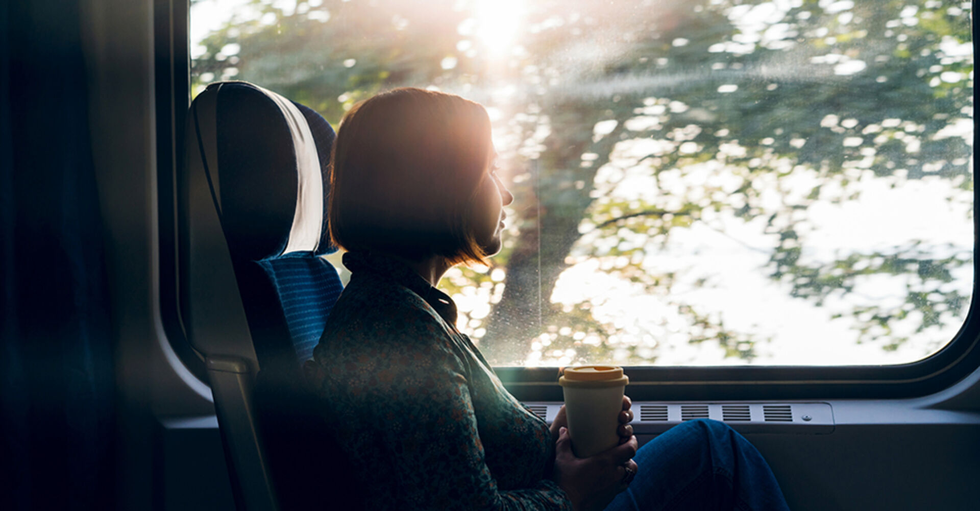 Frau genießt die Aussicht im fahrenden Zug | Credit: iStock.com/Svetlana Ivanova