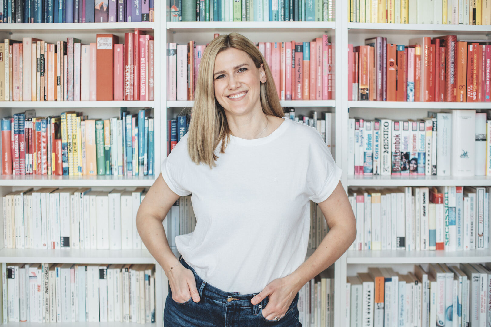 Desiree Schweiger vor einem „Rainbow Bookshelf“