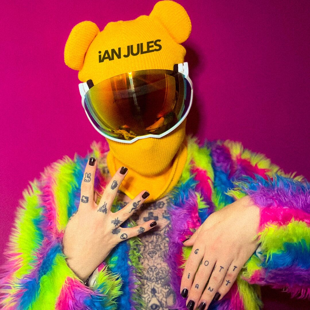 Der Influencer Ian Jules in einer regenbogenfarbenen Felljacke mit gelber Schimütze und Spiegelvisir