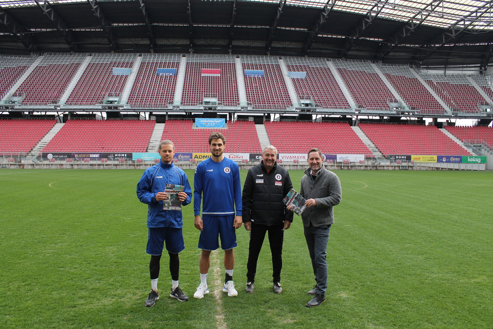 Weekend Geschäftsführer Daniel Klier mit Peter Pacult, Thorsten Mahrer und Patrick Greil auf dem Rasen des Wörthersee Stadions
