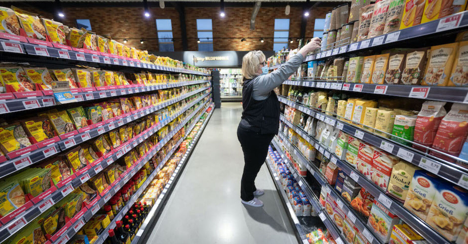 Verkäuferin füllt Regale auf