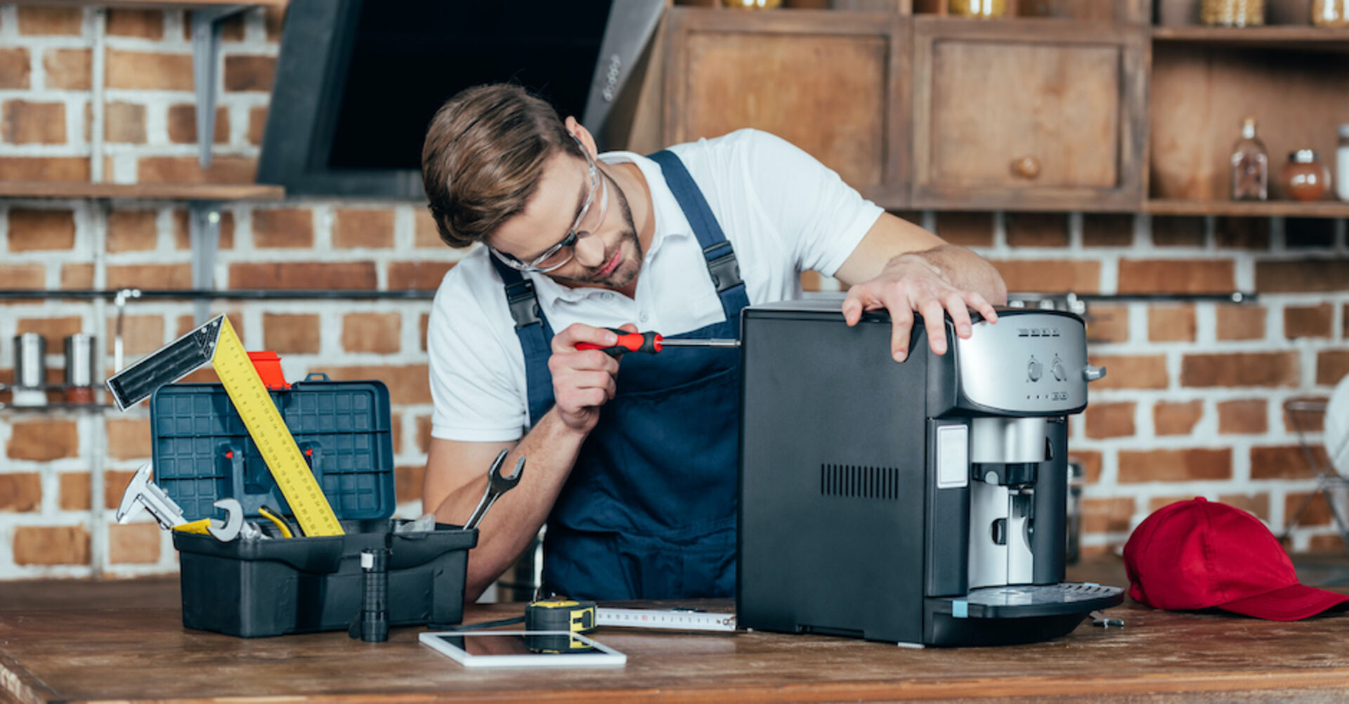 Mann repariert Kaffeemaschine I Credit: iStockphoto.com/LightFieldStudios