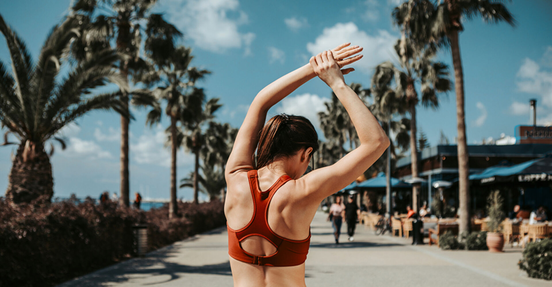 Junge Frau von hinten beim Oberarm-Training im Freien | Credit: iStock.com/YakobchukOlena