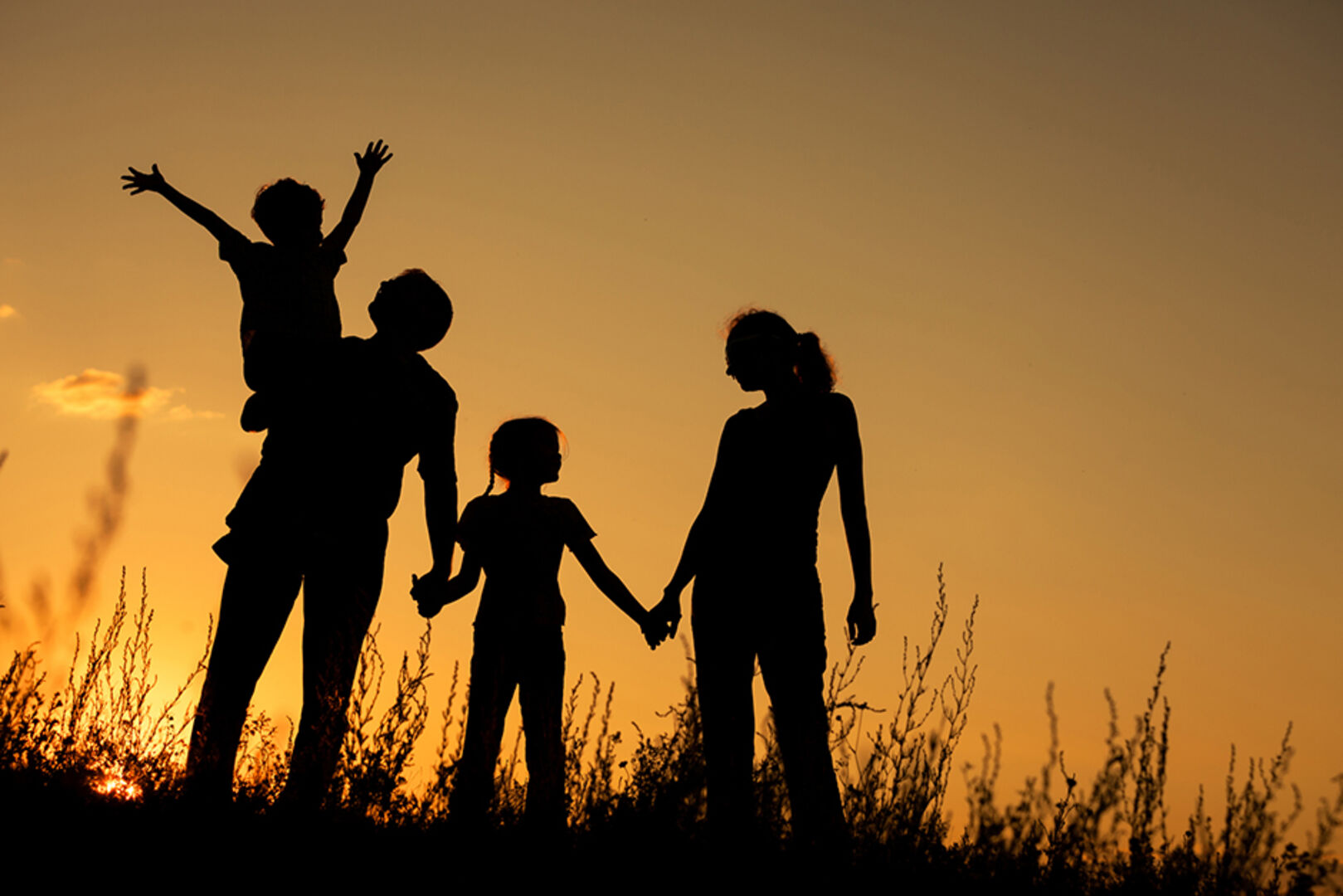 Junge Familie im Sonnenuntergang | Credit: iStock.com/altanaka