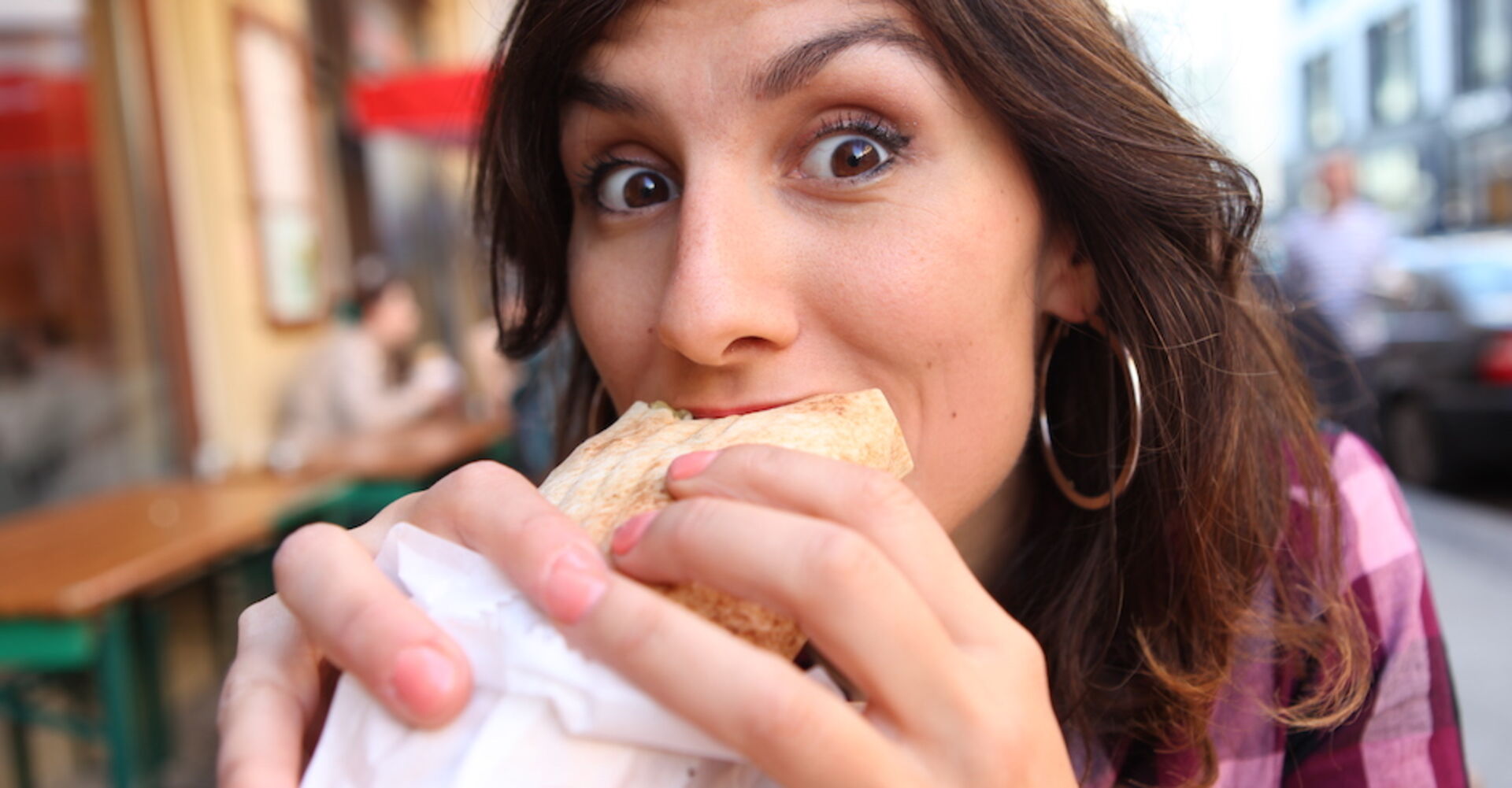 Frau isst Döner auf der Straße | Credit: iStock.com/carpinxo